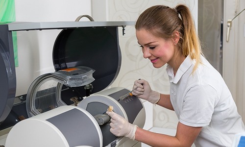 A person using a CEREC machine to create same-day crowns