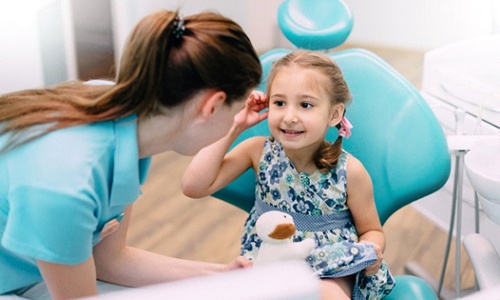 Little girl talking to her Braintree dentist 