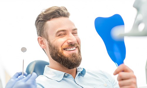 Man looking at smile in mirror