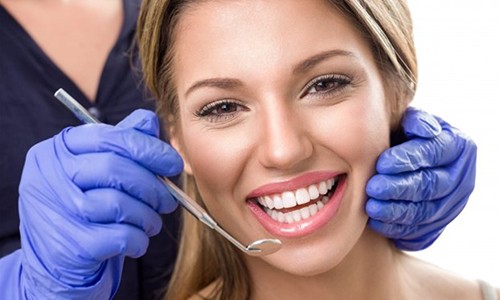 a person smiling while visiting their dentist