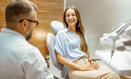 Female patient smiling at cosmetic dentist during initial consultation