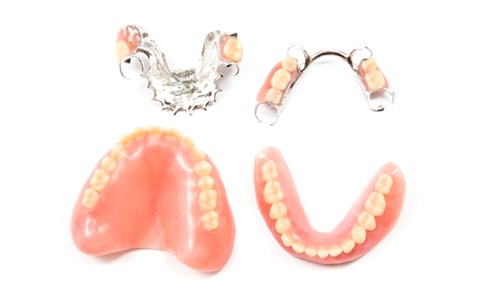 full and partial dentures against white background