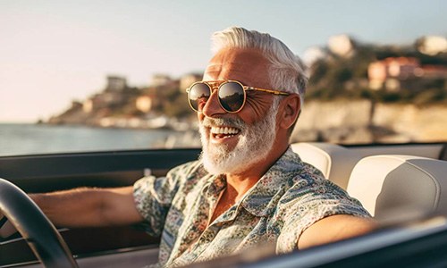 Senior man in sunglasses driving along beach