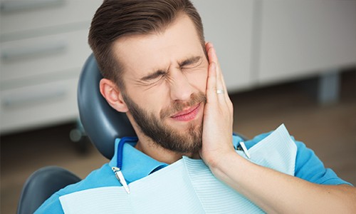 Man holding jaw in pain