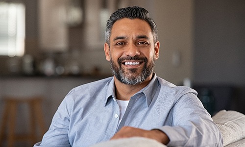 Mature man smiling on couch at home