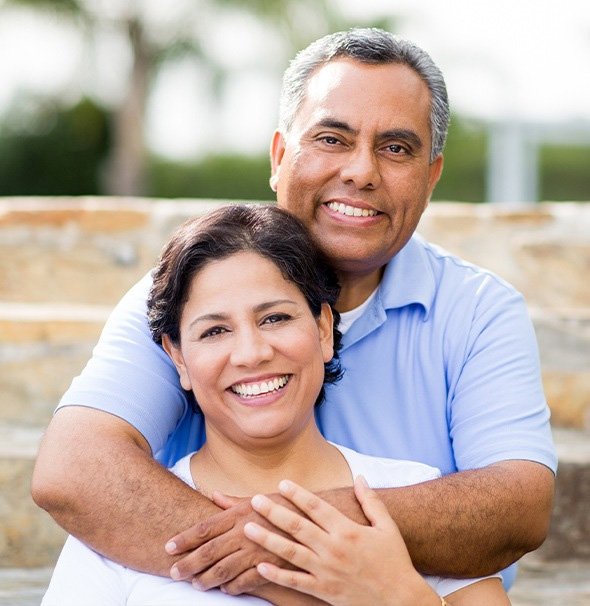 a couple showing off their healthy, beautiful smiles