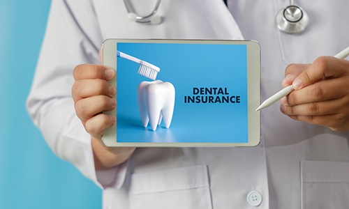 Dentist holding tablet that reads Dental Insurance 