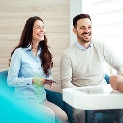 Couple smiling while talking to Invisalign dentist in Braintree