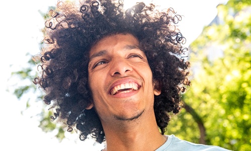 person smiling and walking outdoors