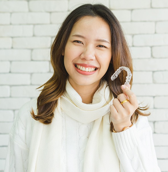 Woman holding an Invisalign tray