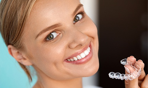 Smiling woman with a clear aligner