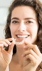 Woman placing Invisalign tray