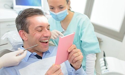 Man looking at smile in mirror