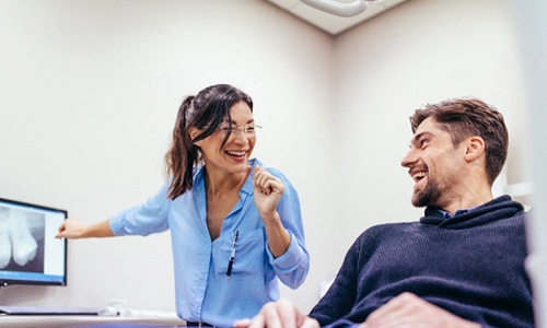 Cosmetic dentist in Braintree smiling while talking to patient