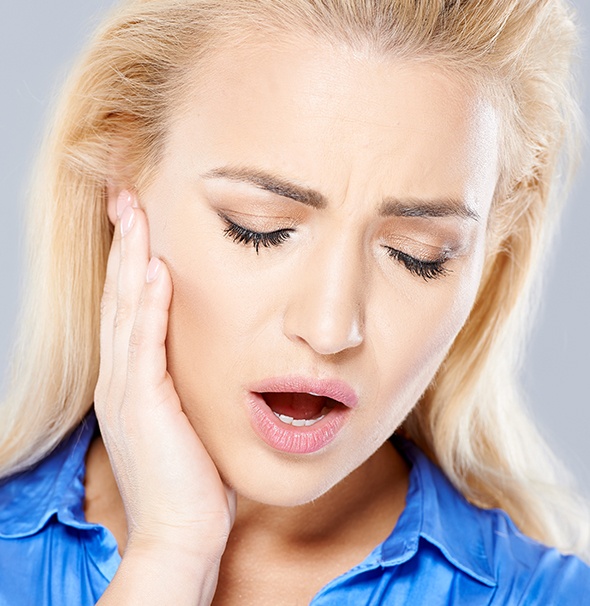 Woman in pain holding jaw