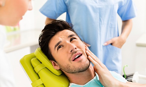 Man holding jaw in pain