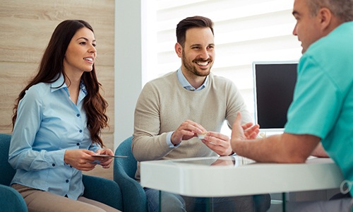 Braintree cosmetic dentist explaining cost of veneers to couple