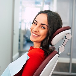 Woman in red shirt smiling in dentist's chair