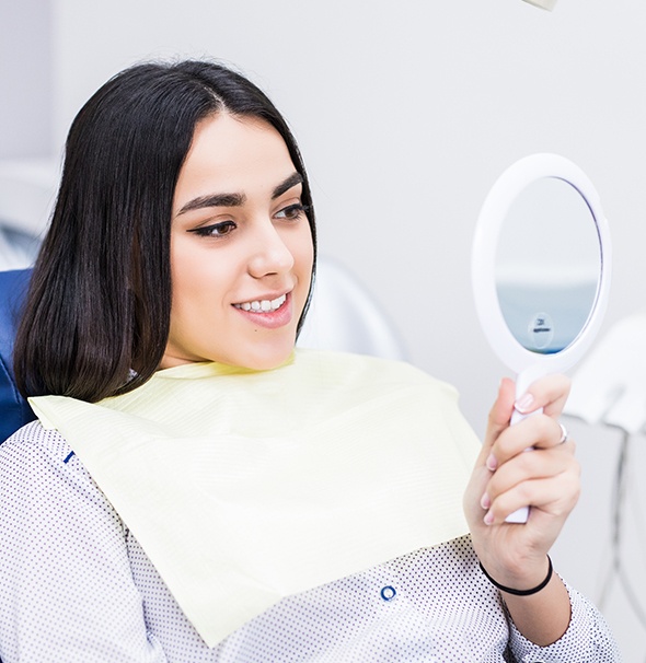 Woman looking at smile in mirror