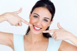 woman pointing to her flawless smile