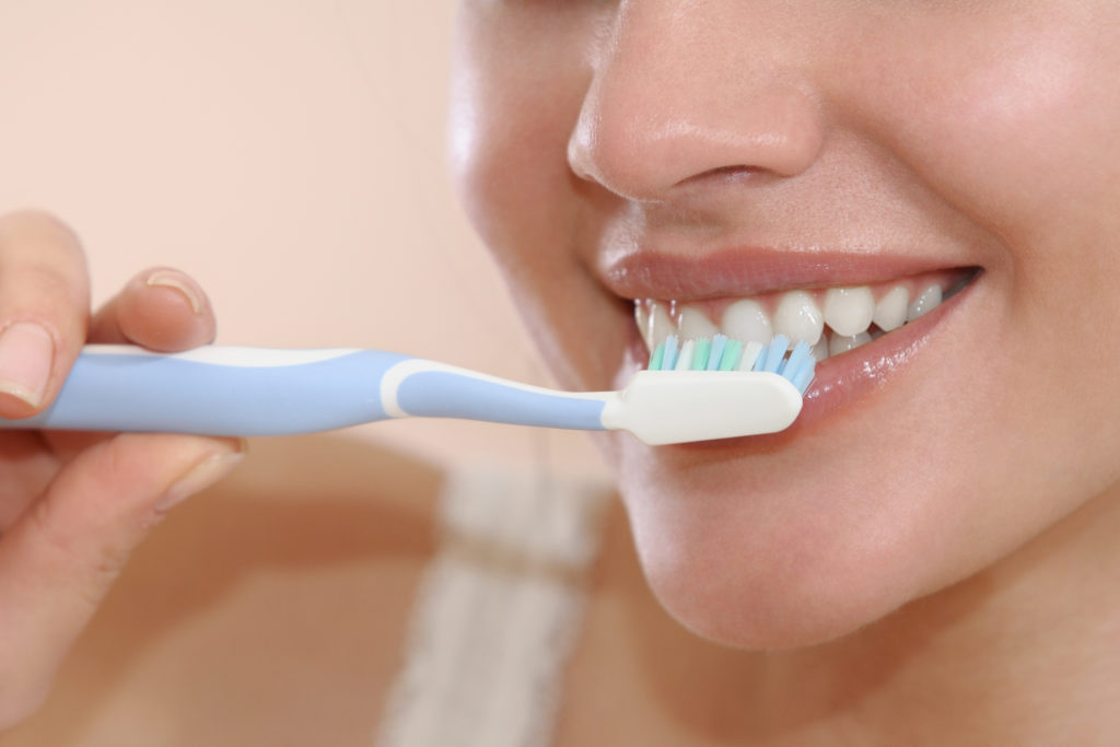 young attractive woman brushing teeth
