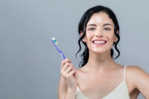 Woman with toothbrush smiles after using toothbrushing tips