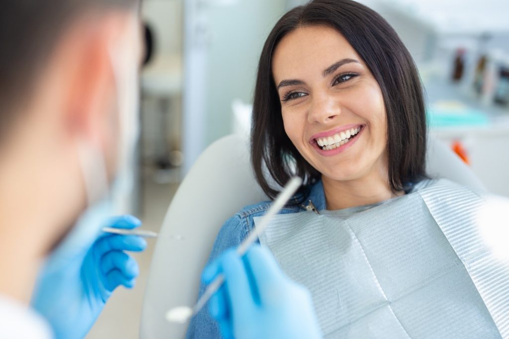 Patient smiling during checkup with cosmetic dentist