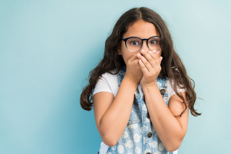 Young girl covering her mouth in shock