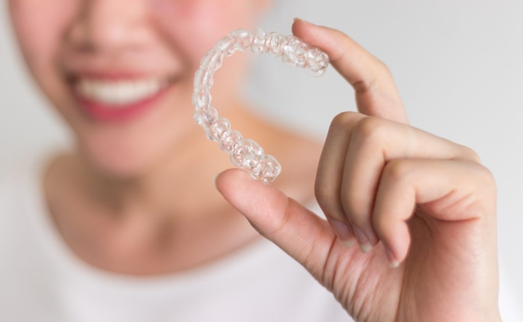 Patient holding up clean Invisalign tray