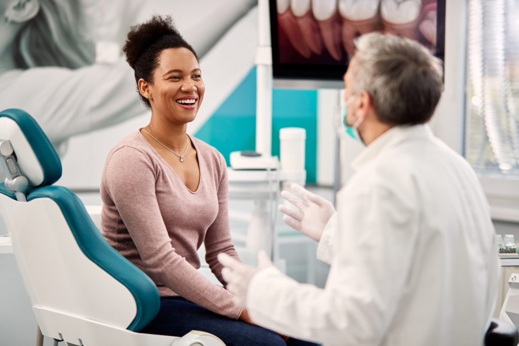 woman smiling while asking dentist questions about smile makeovers