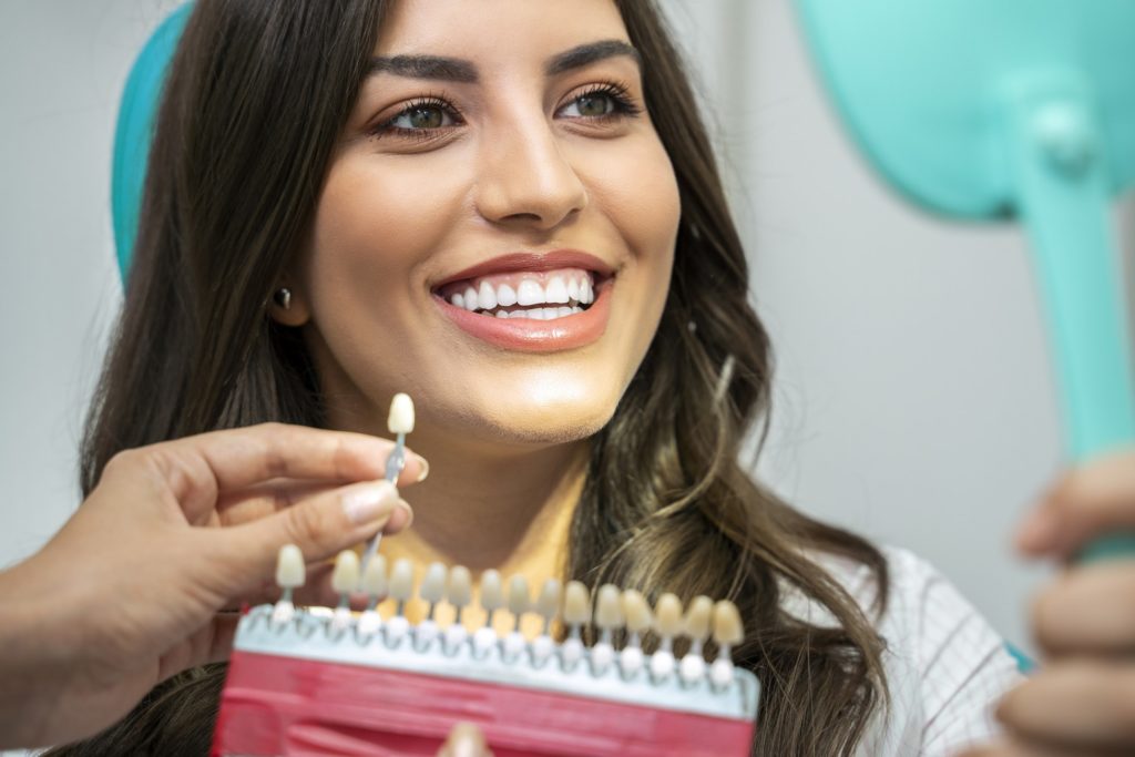 Closeup of smiling woman looking in dental mirror