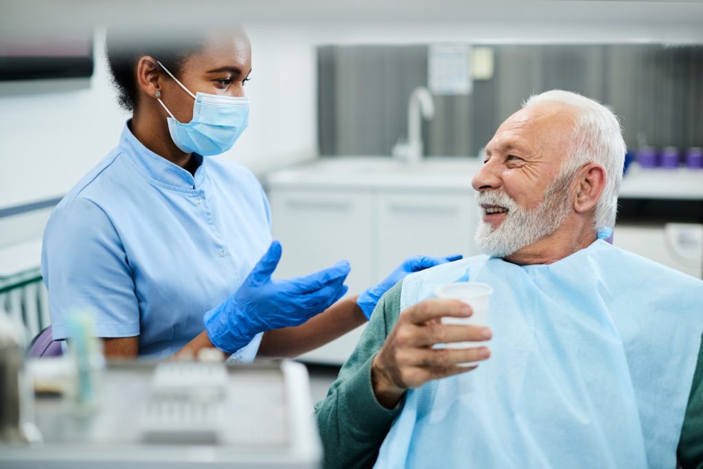 Dental hygienist talking to patient after routine cleaning