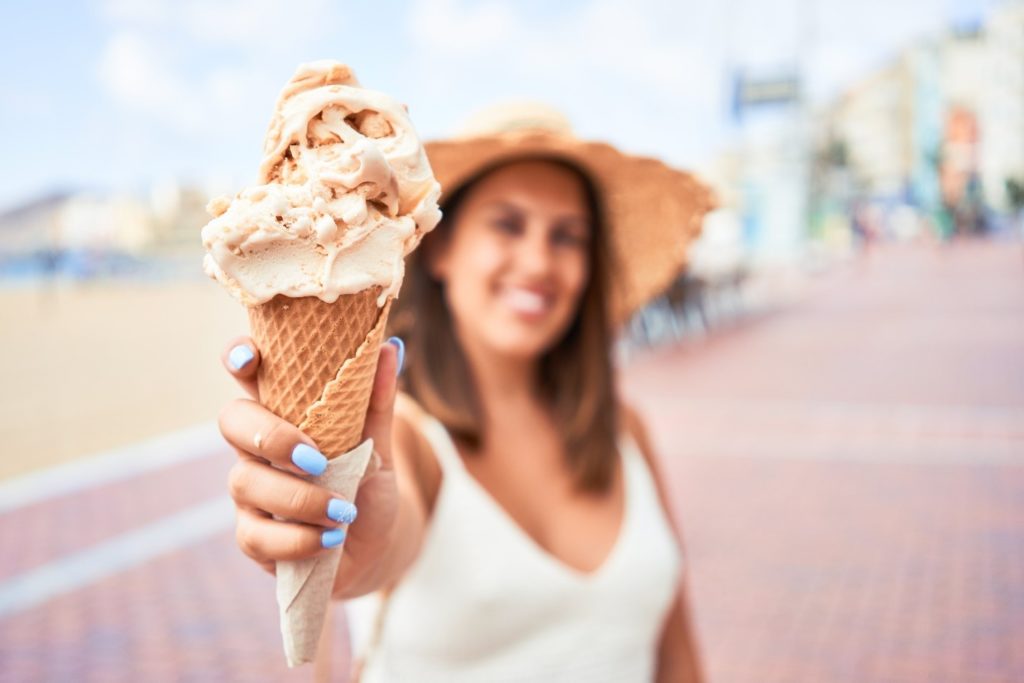 Woman smiling while holding ice cream cone