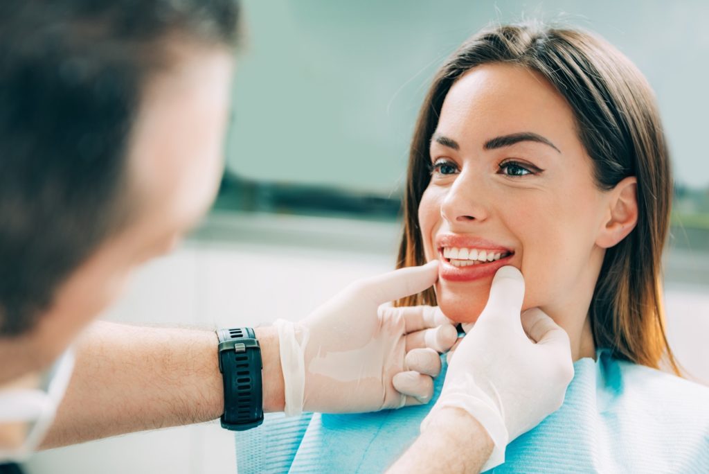 Dentist examining patient's teeth at checkup