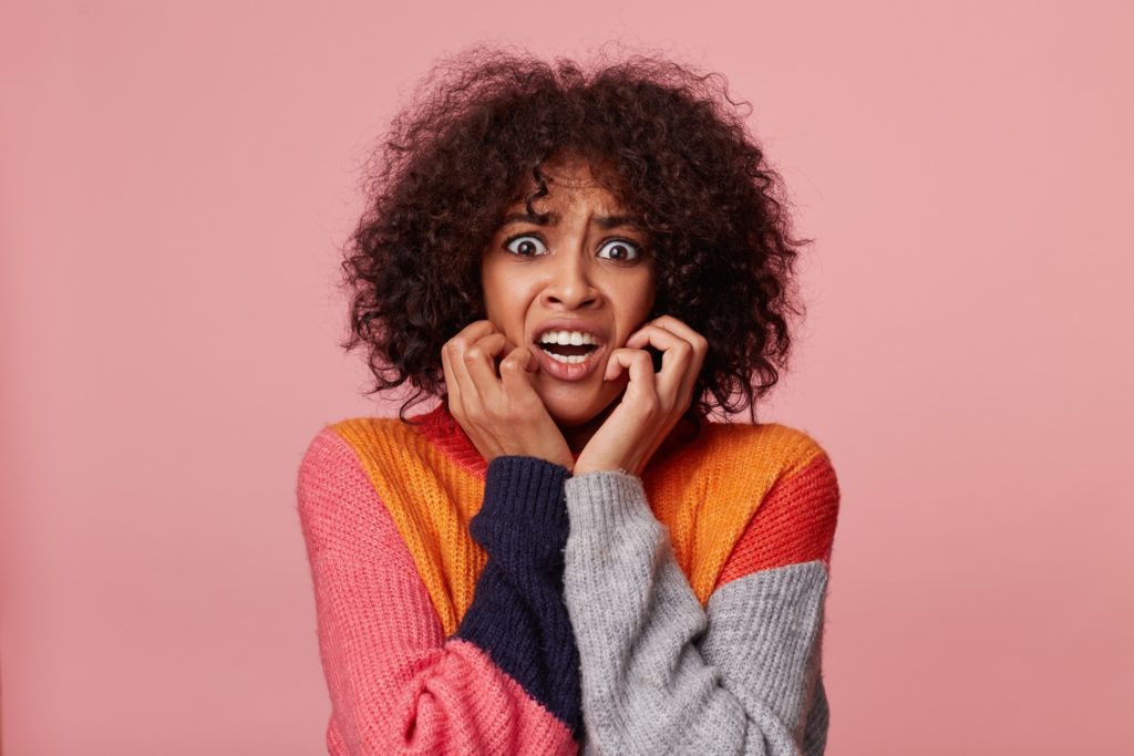 Woman in color-blocked sweater looking scared