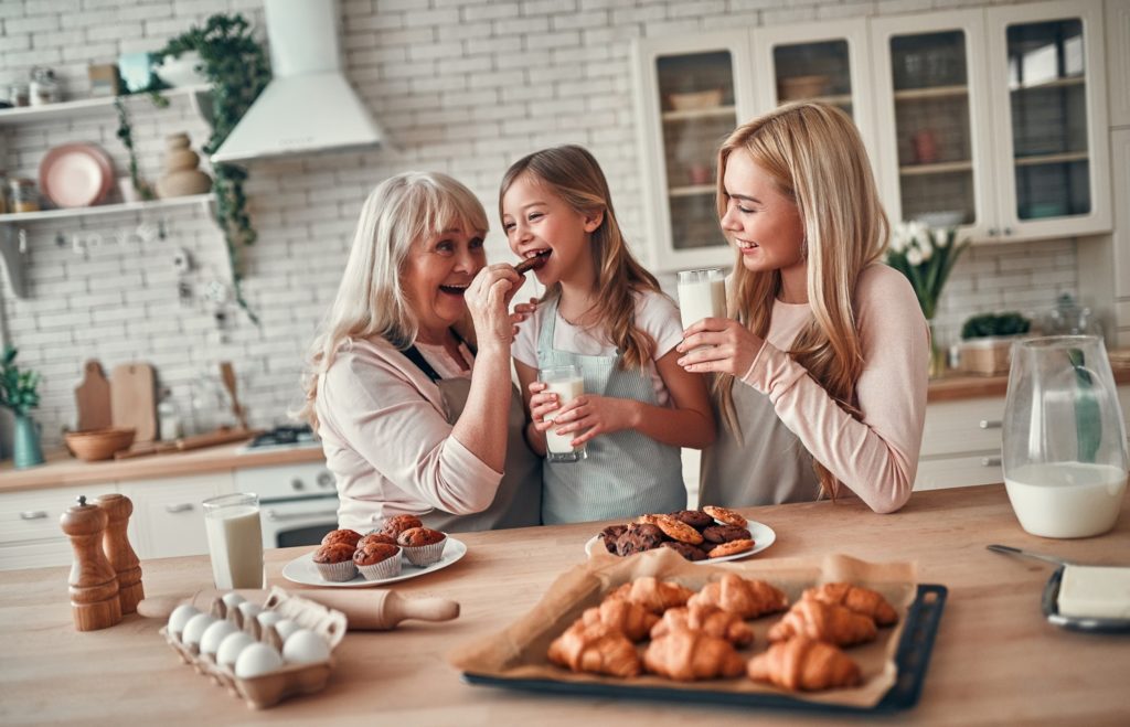 Family smiling while baking holiday treats together