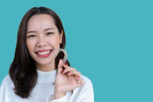 a woman holding her Invisalign aligner